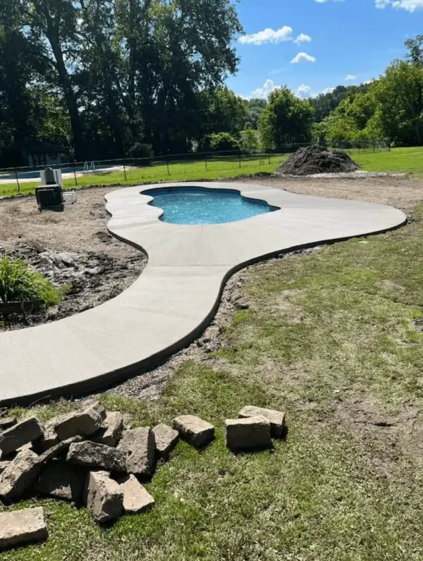 Curved concrete pool deck poured around a freeform pool in Elma NY by Cornerstone Concrete of WNY