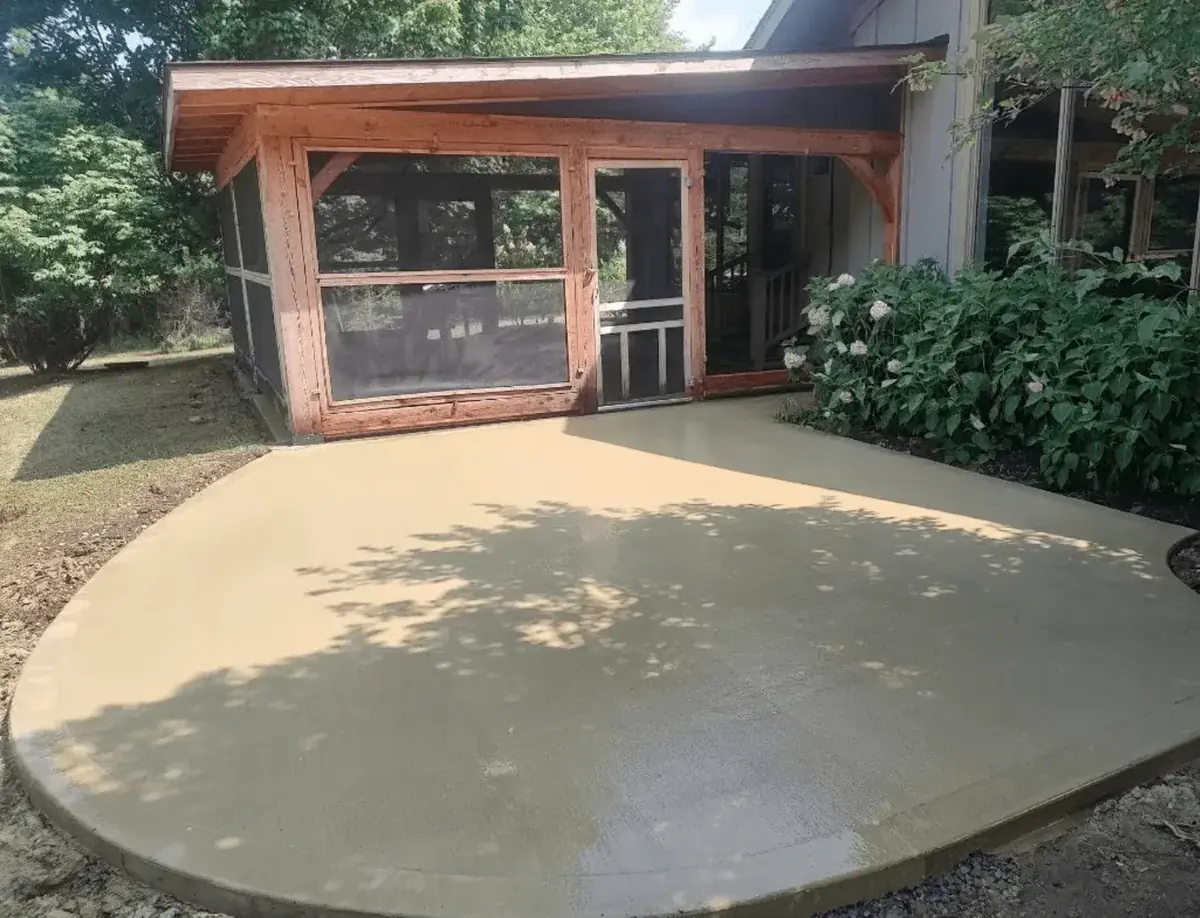 Stained concrete patio with a rounded edge outside a screened porch in East Aurora NY — Cornerstone Concrete of WNY