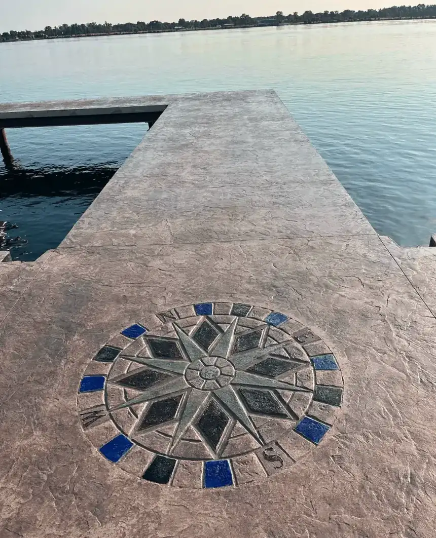 Stamped and stained concrete waterfront deck with a custom compass rose medallion on Grand Island NY by Cornerstone Concrete of WNY